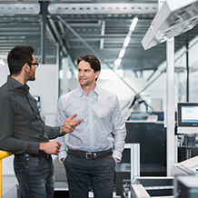 Two men talking in a production hall.