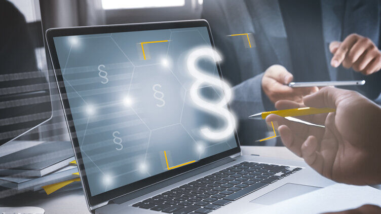 A laptop with a paragraph symbol on a table.