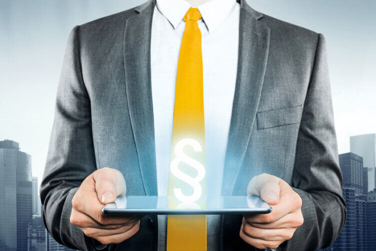 Man in a suit holding a mobile device with a paragraph logo on it.