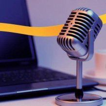 Microphone in front of a laptop with a teacup in the background