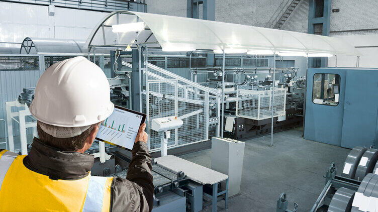 Man with a tablet in front of a machine
